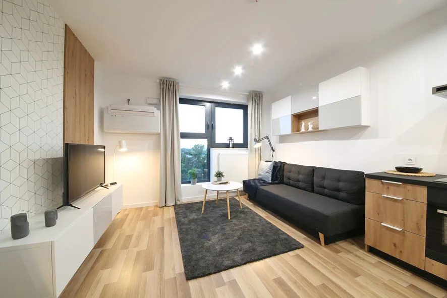 Apartament Wrocław Legnicka — klimatyzowany salon z widokiem na panoramę